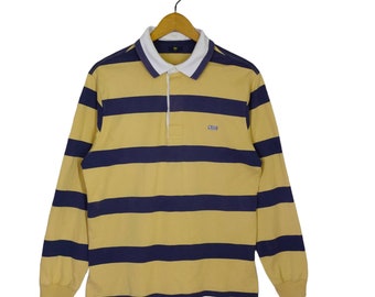 May include: A yellow and navy blue striped long-sleeve rugby shirt with a white collar and a small logo on the chest.