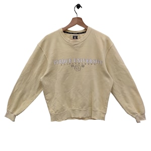 May include: A light yellow sweatshirt with the text "Purdue University Boilermakers 1869" in white and black lettering.