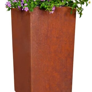 Op de afbeelding: Een vierkante plantenbak van roestig bruin metaal, gevuld met verschillende paarse en oranje bloemen.