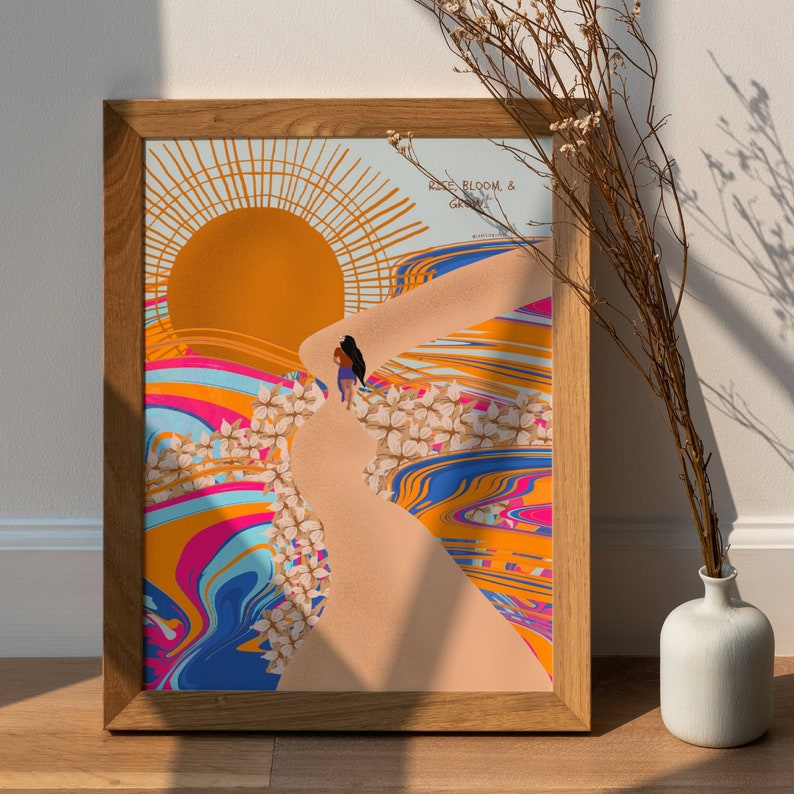 May include: A framed print with a colourful abstract design featuring a woman walking up a path with a sun and flowers in the background. The text "Rise, Bloom, & Grow" is at the top of the print.