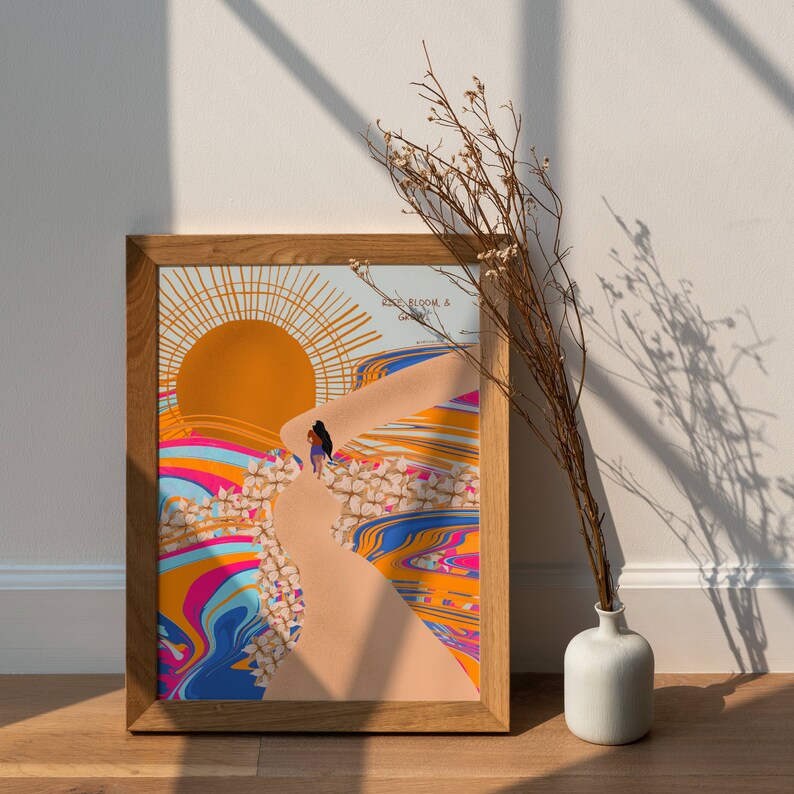 May include: A framed print with a colorful abstract design featuring a woman walking up a path towards a sun. The text "Rise, Bloom, & Grow" is at the top of the print.
