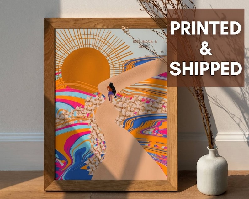 May include: A framed print with a colourful abstract design featuring a sun, a path, and flowers. The text "Rise Bloom & Gather" is visible in the top right corner of the print.