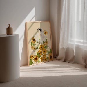 May include: A framed illustration of a person with a floral pattern made of sunflowers and other flowers. The background is a light beige color.