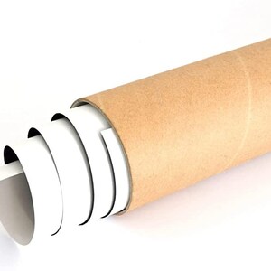 May include: A rolled up poster or print is being unrolled from a brown cardboard tube. The poster is white with black edges.