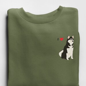 Może przedstawiać: Zielona bluza z nadrukiem czarno-białego psa husky i tekstem "I &hearts;" z przodu.
