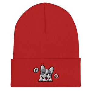 Puede incluir: Gorro de punto rojo con un bulldog franc&eacute;s bordado en blanco y gris con una burbuja de di&aacute;logo que dice "Hola" y un coraz&oacute;n.