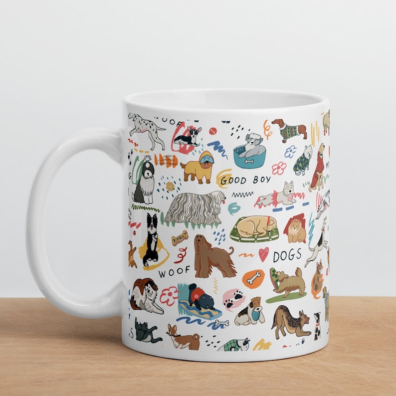 May include: White ceramic mug with a colorful illustration of various dog breeds, including a dachshund, a poodle, a golden retriever, and a pug. The mug features the words "Woof", "Good Boy", and "I Love Dogs".