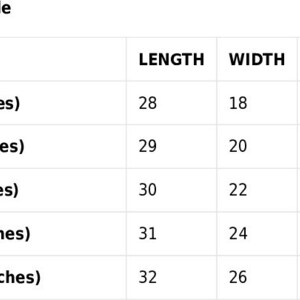 May include: A size guide table with measurements in inches for various sizes: S, M, L, XL, and 2XL. The table shows length, width, and chest measurements for each size, providing detailed sizing information.