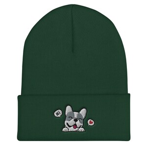 Puede incluir: Un gorro de punto verde oscuro con una imagen bordada en blanco y gris de un bulldog franc&eacute;s con un coraz&oacute;n rojo y la palabra "HI" en un globo de di&aacute;logo.