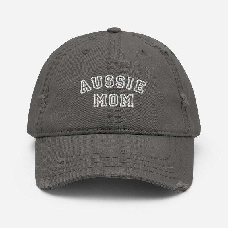 May include: A gray distressed baseball cap with white embroidered text that reads "Aussie Mom".