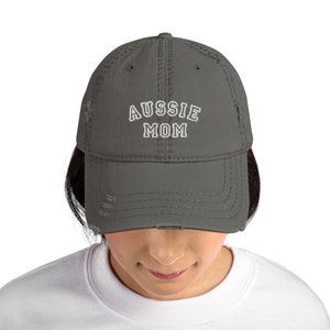 May include: A charcoal gray distressed baseball cap with white embroidered text that reads "Aussie Mom".