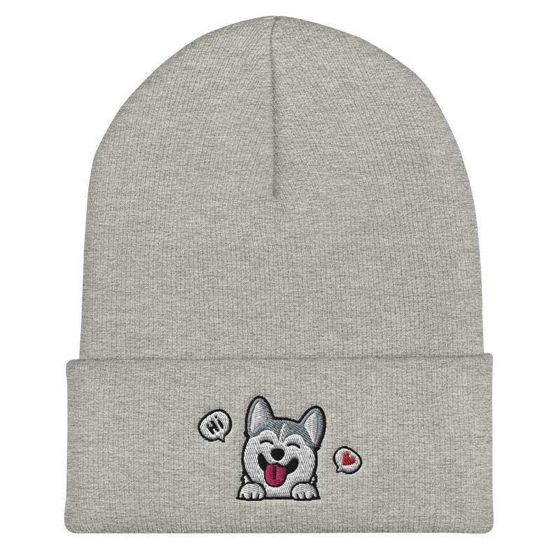 K&ouml;nnte beinhalten: Graue M&uuml;tze mit einem gestickten Husky-Hund in Wei&szlig; und Grau, der die Zunge herausstreckt. Der Hund sagt "Hallo" in einer Sprechblase und hat ein rotes Herz in einer anderen Sprechblase.