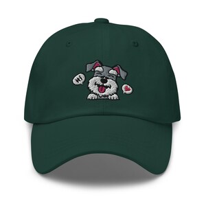 K&ouml;nnte beinhalten: Eine dunkelgr&uuml;ne Baseballkappe mit einem gestickten Bild eines grau-wei&szlig;en Hundes mit herausgestreckter rosa Zunge. Der Hund tr&auml;gt ein rotes Herz und hat eine Sprechblase mit der Aufschrift "Hallo".