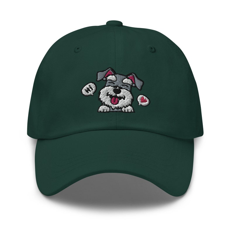 K&ouml;nnte beinhalten: Eine dunkelgr&uuml;ne Baseballkappe mit einem gestickten Bild eines grau-wei&szlig;en Hundes mit herausgestreckter rosa Zunge. Der Hund tr&auml;gt ein rotes Herz und hat eine Sprechblase mit der Aufschrift "Hallo".