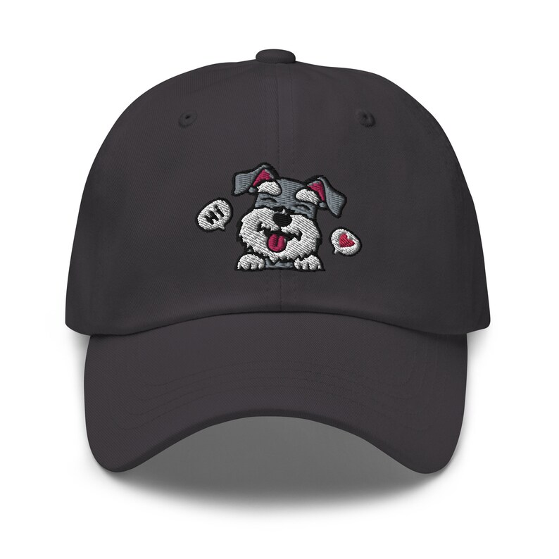 K&ouml;nnte beinhalten: Eine dunkelgraue Baseballkappe mit einem gestickten Bild eines l&auml;chelnden Zwergschnauzers mit einer Sprechblase, die "Hallo" sagt, und einem Herzen.