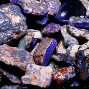 May include: A collection of rough, uncut opals in various sizes and shapes. The opals display a range of colors, including blues, grays, and browns, with flashes of iridescent color. The stones have a natural, unpolished appearance, showcasing their raw beauty.