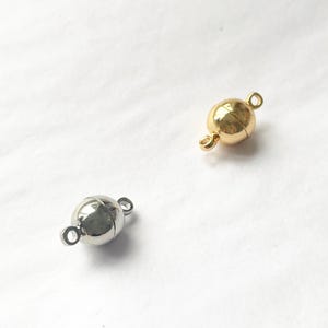 May include: Two magnetic clasps for jewellery making. One is gold and the other is silver.