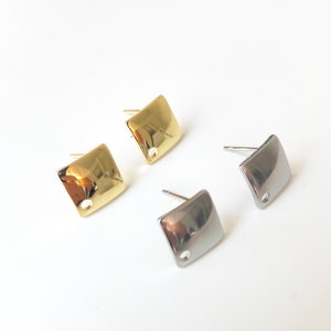 May include: Two pairs of square stud earrings, one pair is gold and the other is silver.