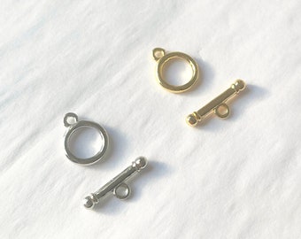 May include: Two sets of metal clasps for jewelry making. One set is gold and the other is silver.