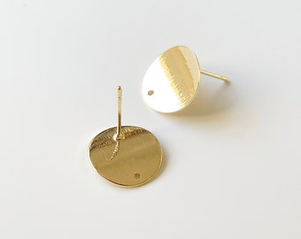 May include: Two gold-toned earring posts with round, flat, textured tops. Each top has a small hole in the center.