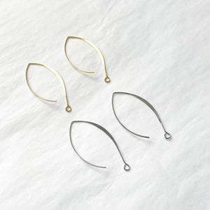 May include: Four earring findings, two gold and two silver, in the shape of a teardrop with a loop at the top.