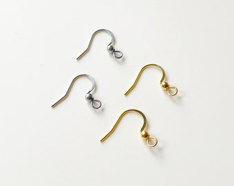 May include: Three earring hooks, two silver and one gold, with small round balls at the end of each hook.