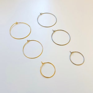 May include: Five pairs of hoop earrings in different sizes. Two pairs are gold, two pairs are silver, and one pair is a smaller size in silver.