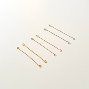 May include: A set of six gold and silver jump rings, each with two loops. The jump rings are arranged in two rows, with the gold rings on top and the silver rings on the bottom.