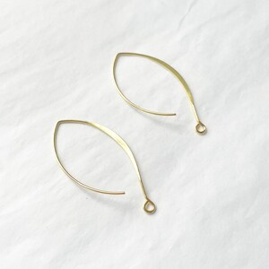 May include: A pair of gold-toned wire earrings with a teardrop shape.