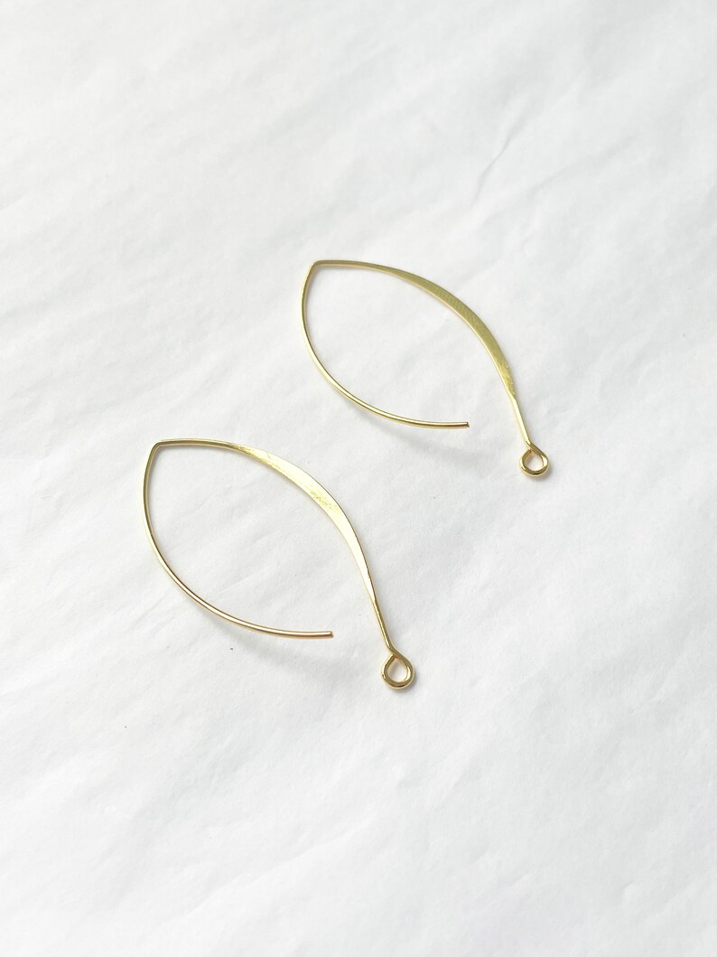May include: A pair of gold-toned wire earrings with a teardrop shape.