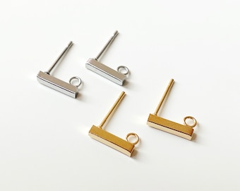 May include: Two pairs of earring findings, one pair is silver and the other is gold. Each finding has a small loop at the end of a short bar.
