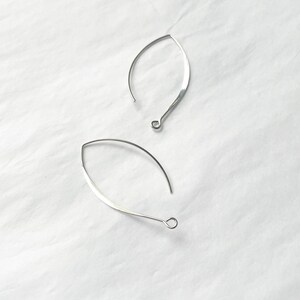 May include: Two silver earring hoops with a slightly curved shape.