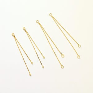 May include: Four gold-toned metal jewelry components, each consisting of a single jump ring connected to two separate, thin, textured chain strands that terminate in smaller individual jump rings at their respective ends.