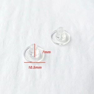 Peut inclure: Deux dos d'oreille en plastique transparent, l'un mesure 10,5 mm de large et 7 mm de haut.