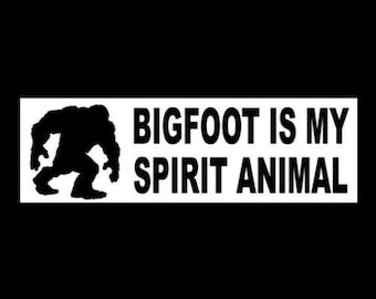 May include: A white sticker with a black silhouette of Bigfoot walking and the text "BIGFOOT IS MY SPIRIT ANIMAL".