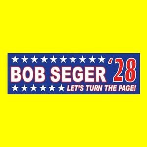 May include: A blue and white political campaign bumper sticker with white stars and the text "BOB SEGER '28 LET'S TURN THE PAGE!"