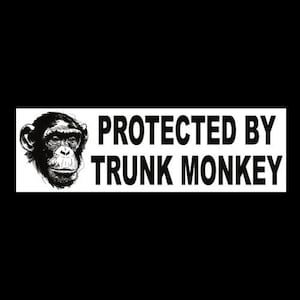 May include: A black and white sticker with the text "PROTECTED BY TRUNK MONKEY". The sticker features a detailed illustration of a monkey's face on the left side. The text is in a bold, sans-serif font.