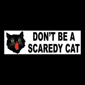 May include: A black and white sticker with a black cat with green eyes and a red mouth. The text on the sticker reads "DON'T BE A SCAREDY CAT".