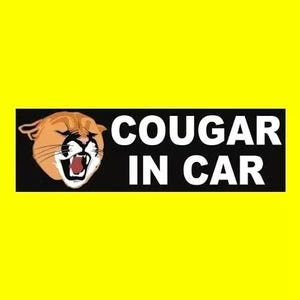May include: Black and white sticker with a cartoon cougar with a red mouth and the text "COUGAR IN CAR" in white letters.
