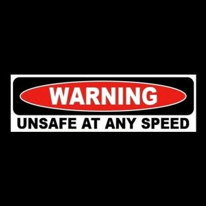 May include: A black and white warning sign with a red oval that says "WARNING" in white letters. The sign says "UNSAFE AT ANY SPEED" in white letters.