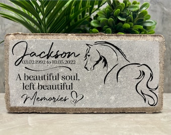 Puede incluir: Una piedra conmemorativa de hormigón gris con una silueta de caballo negro y la inscripción "Jackson 03.02.1992 al 10.05.2022 Un alma hermosa, dejó hermosos recuerdos".