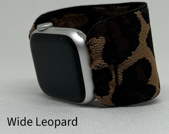 May include: A black and brown leopard print watch band for an Apple Watch. The band is made of a stretchy material and has a wide design.