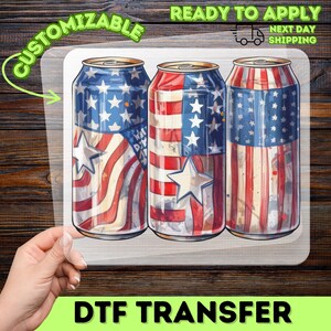 May include: DTF transfer showing three beverage cans decorated with the American flag. The cans are in red, white, and blue, with stars and stripes. The image includes the text "CUSTOMIZABLE" and "READY TO APPLY NEXT DAY SHIPPING".