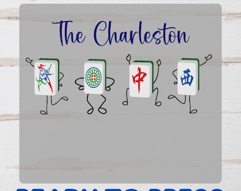 May include: DTF Transfer design featuring the text "The Charleston" above four animated Mahjong tiles with arms and legs. The tiles are white with green borders and various colorful symbols. The text "READY TO PRESS" is below.
