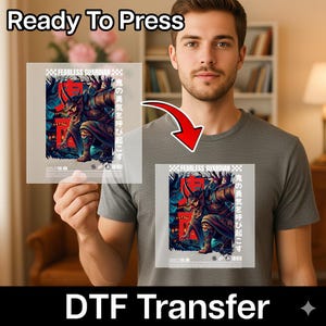 May include: A DTF (Direct to Film) transfer featuring a detailed graphic of a Japanese demon warrior with the text "FEARLESS GUARDIAN" and Japanese characters. The transfer is shown being applied to a gray t-shirt. The words "Ready To Press" are at the top.