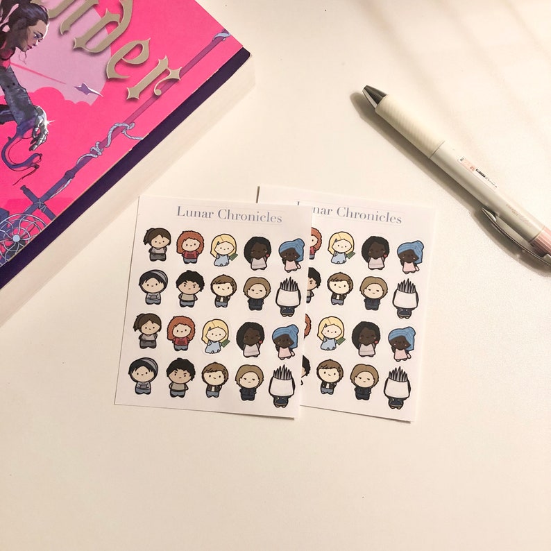 May include: Two sheets of stickers featuring illustrations of characters from the Lunar Chronicles book series. The stickers are on a white background and have the title "Lunar Chronicles" printed on them.