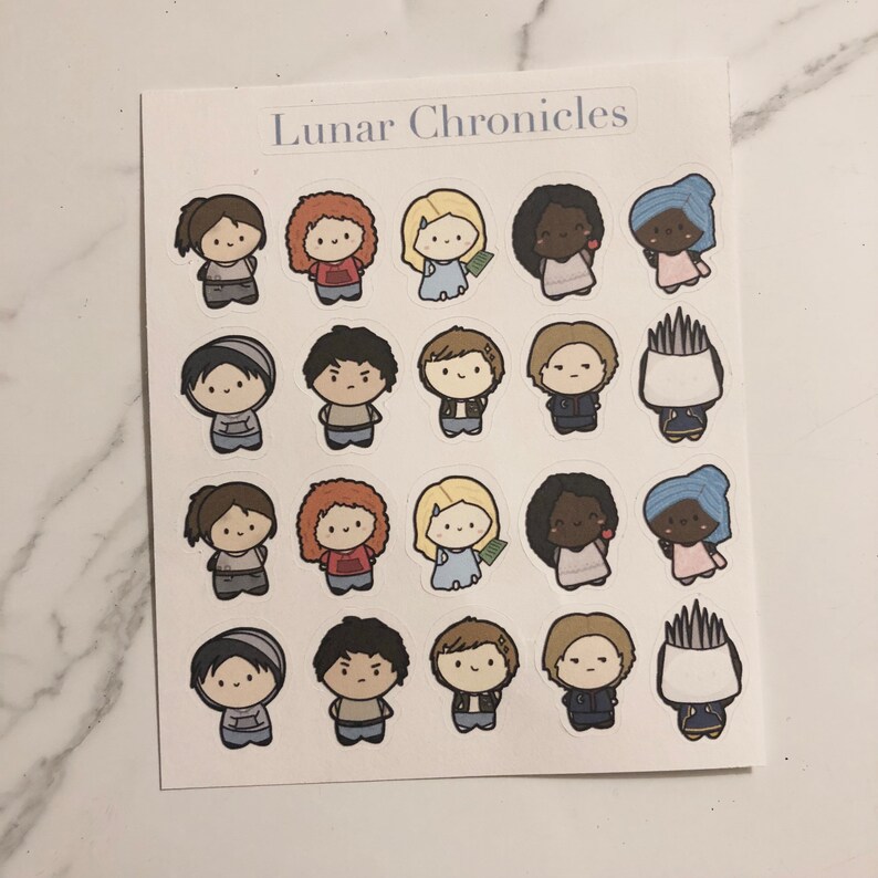 May include: A sheet of stickers featuring characters from the Lunar Chronicles book series. The stickers are in a cartoon style and feature a variety of characters, including Cinder, Scarlet, Cress, and Winter. The stickers are printed on white paper and have a glossy finish.