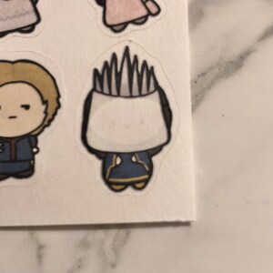 May include: A cartoon character with a white head and a blue and yellow outfit. The character has a spiky white hairdo.