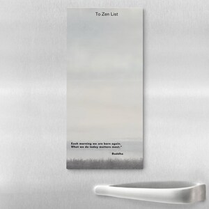 May include: A rectangular notepad with a serene landscape design. The text "To Zen List" is at the top, with a quote by Buddha at the bottom: "Each morning we are born again. What we do today matters most."