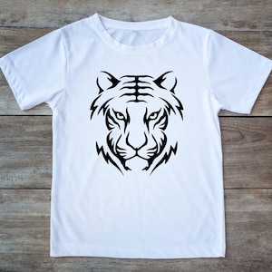 Pode incluir: Camiseta branca com um design de cabeça de tigre tribal preto.
